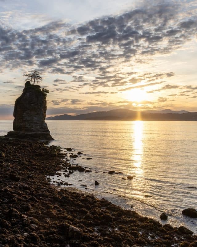 Siwash Rock from the Stanley Park shoreline at sunset